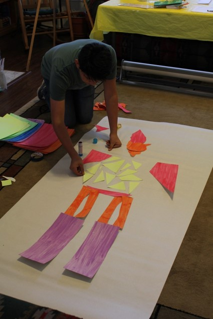 Club member on floor creating a life-sized collage in the style of Matisse.