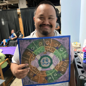 Participant showing the Aztec Sun Stone he created using a template, colored pencils, and his imagination.