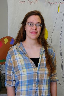 Arielle with long brown hair, glasses, and a plaid shirt.