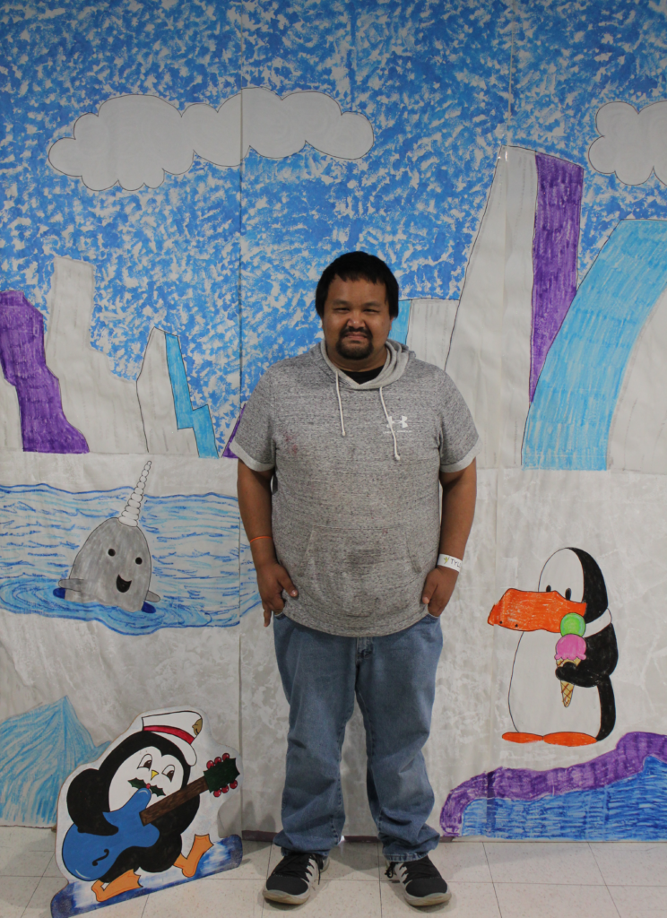 Participant posing in front of a North Pole scene for a holiday card.